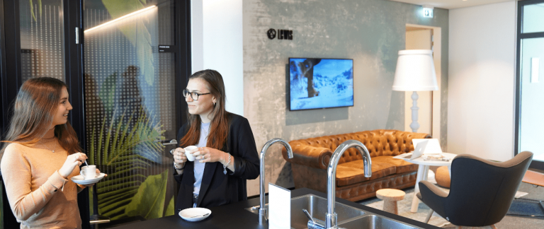 two LEWIS employees in the office kitchen