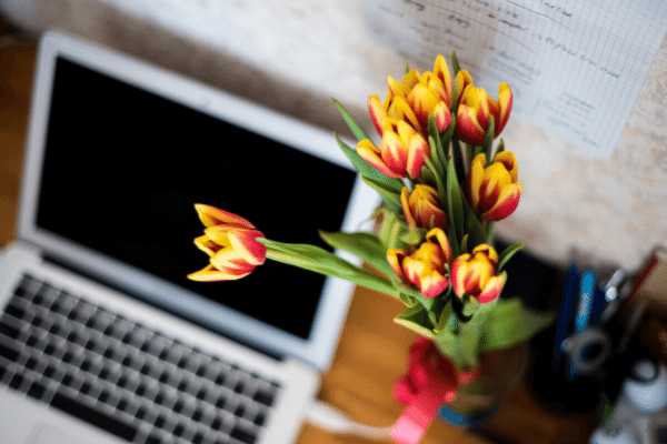 Flowers next to laptop, creating media list